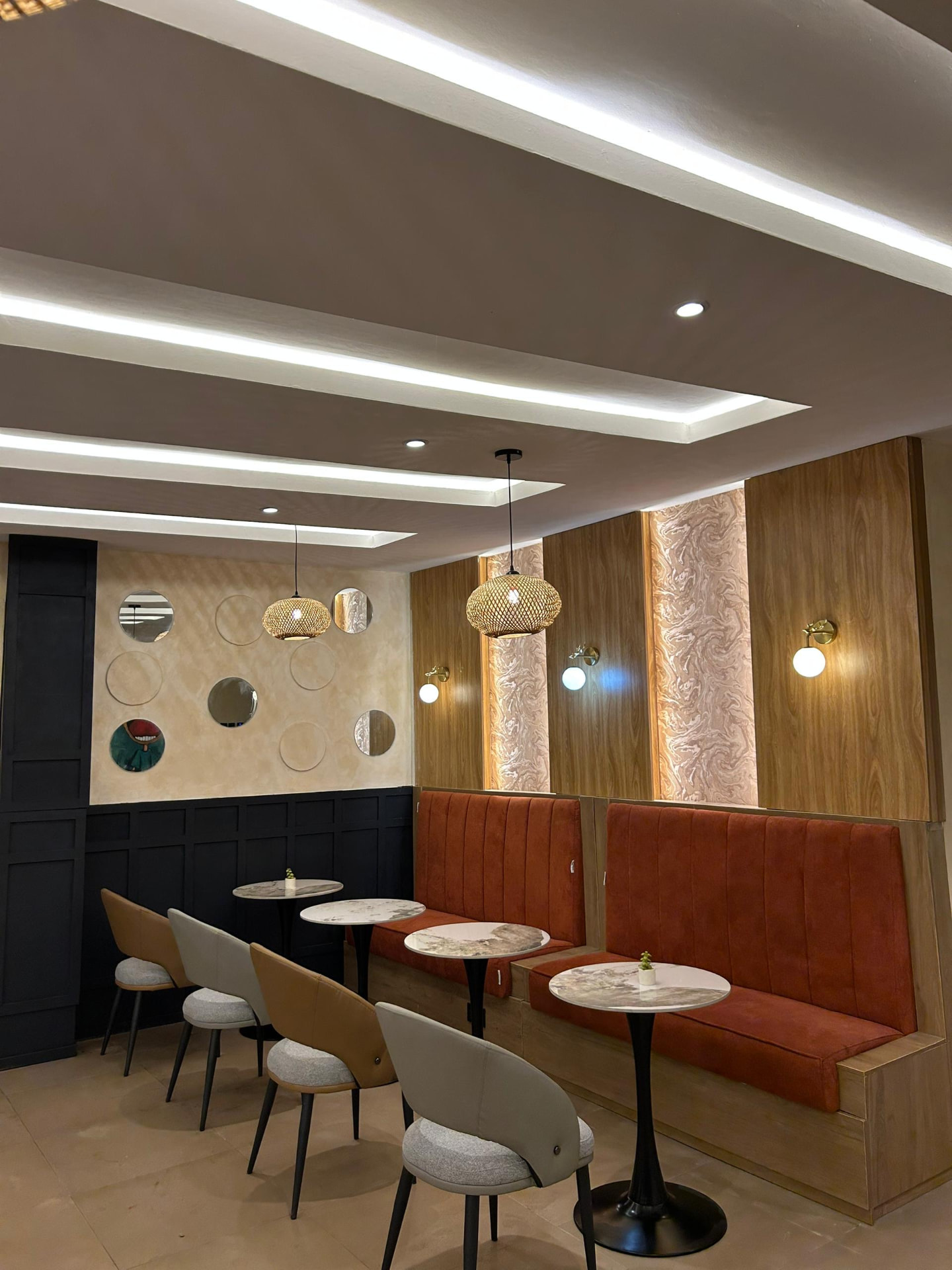 Banquette seating framed by the circular mirror wall
