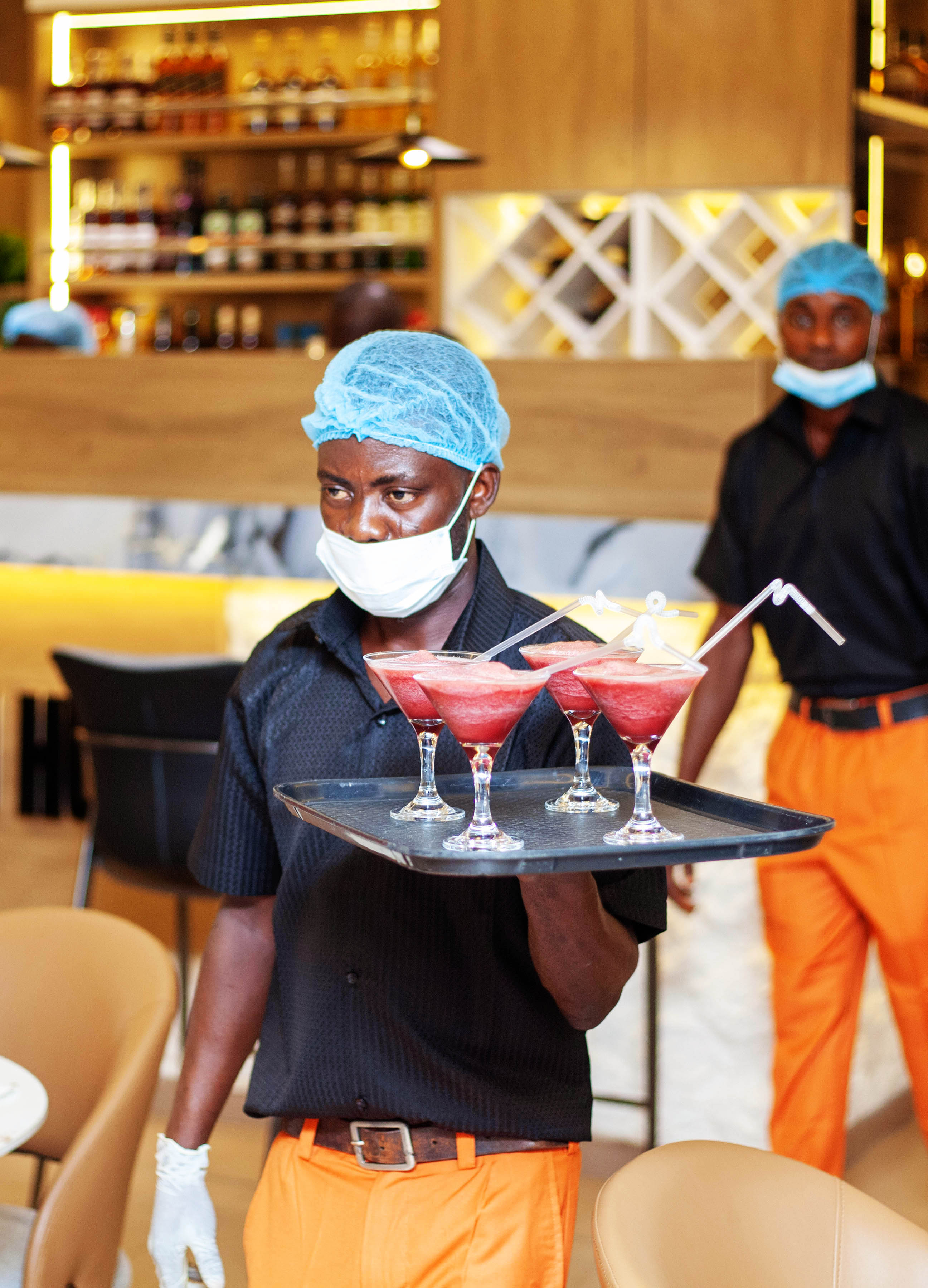 Server carrying freshly made cocktails at the bar